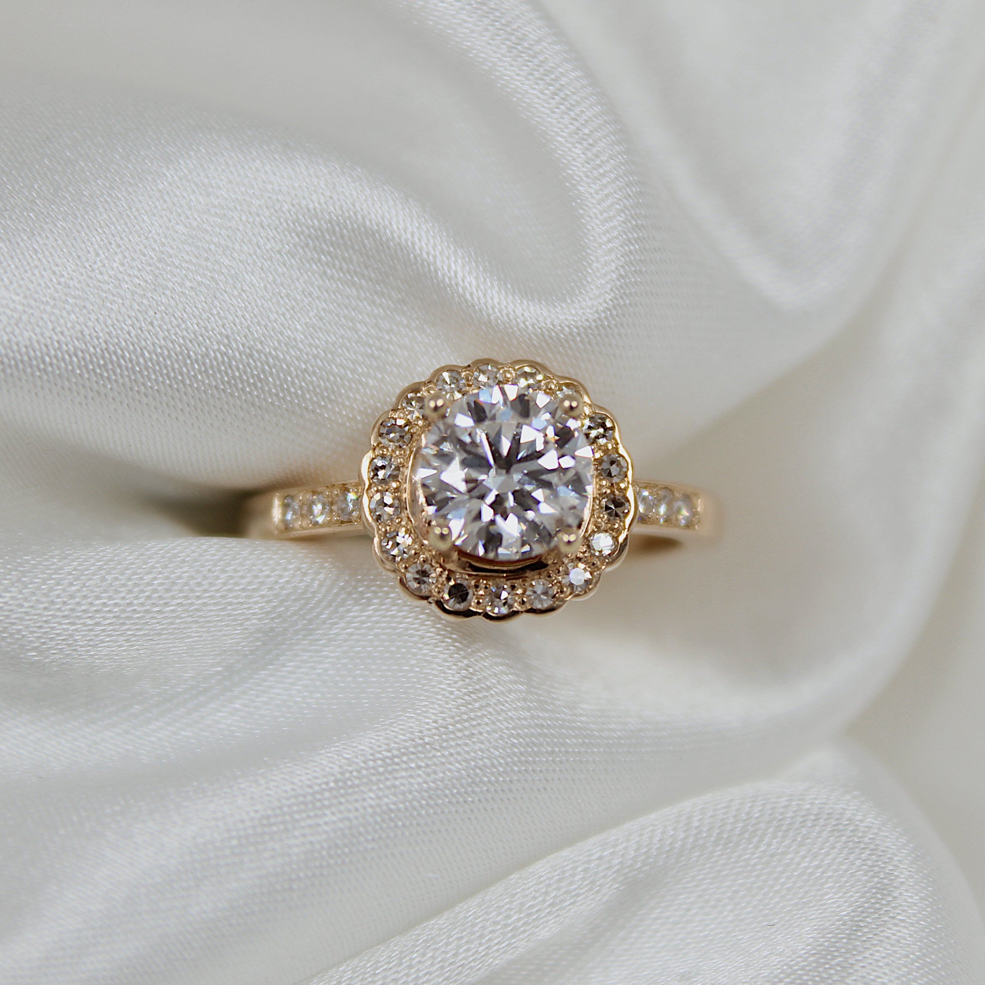 Vintage style Large diamond ring with diamond halo on a white fabric background