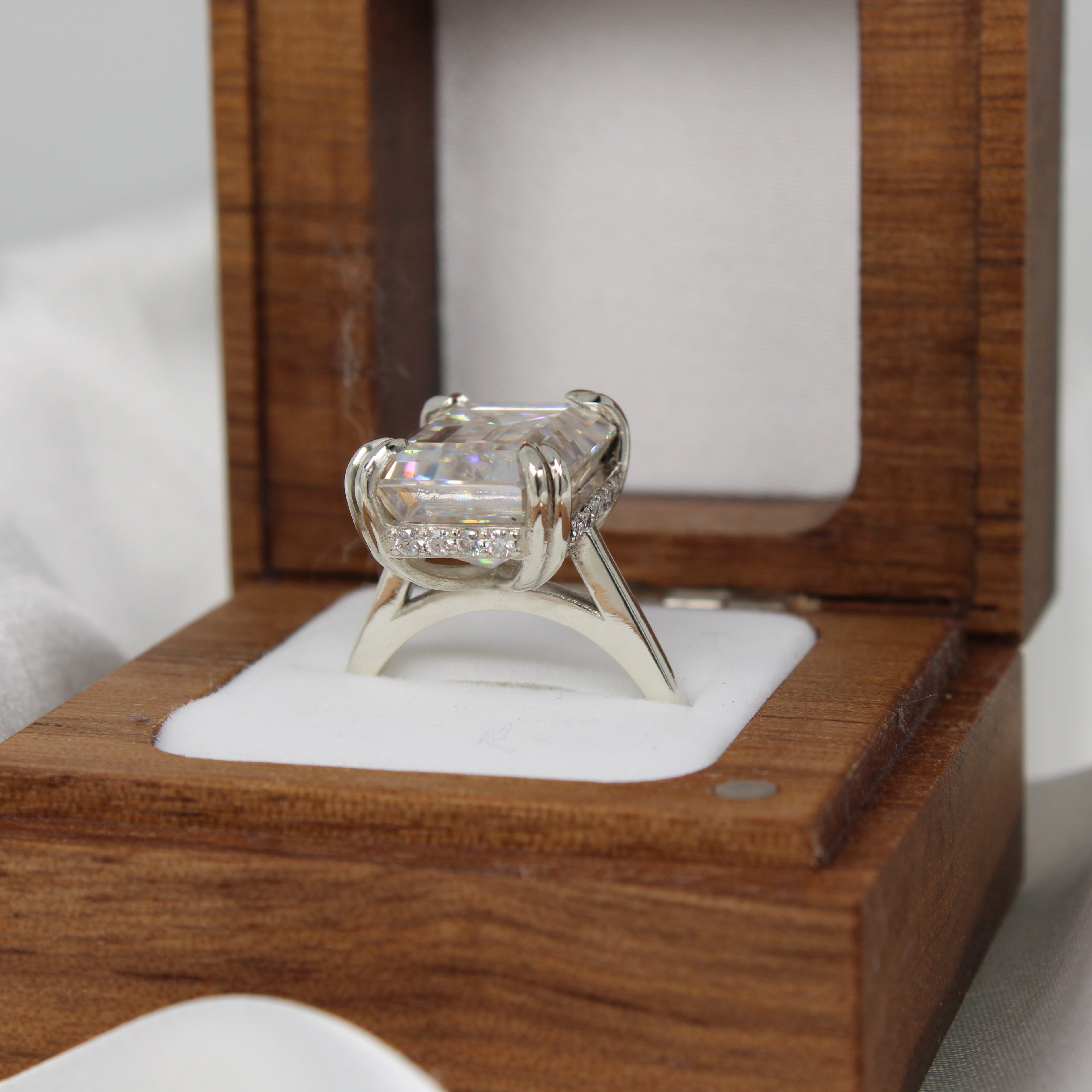Platinum ring in a wooden box on a white fabric background