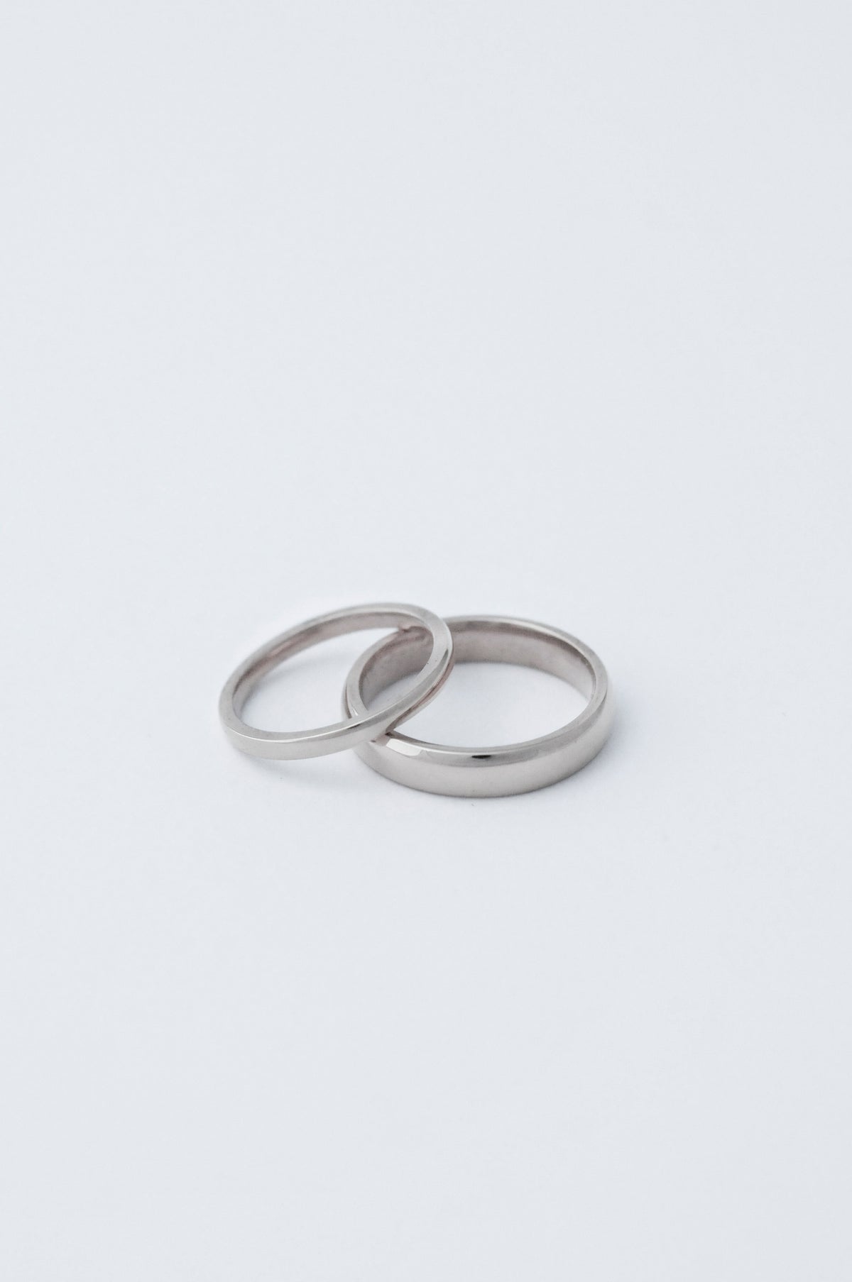 two court wedding bands staggered on top of each other. The bottom ring is 5mm thick and the top one is 2mm both in platinum