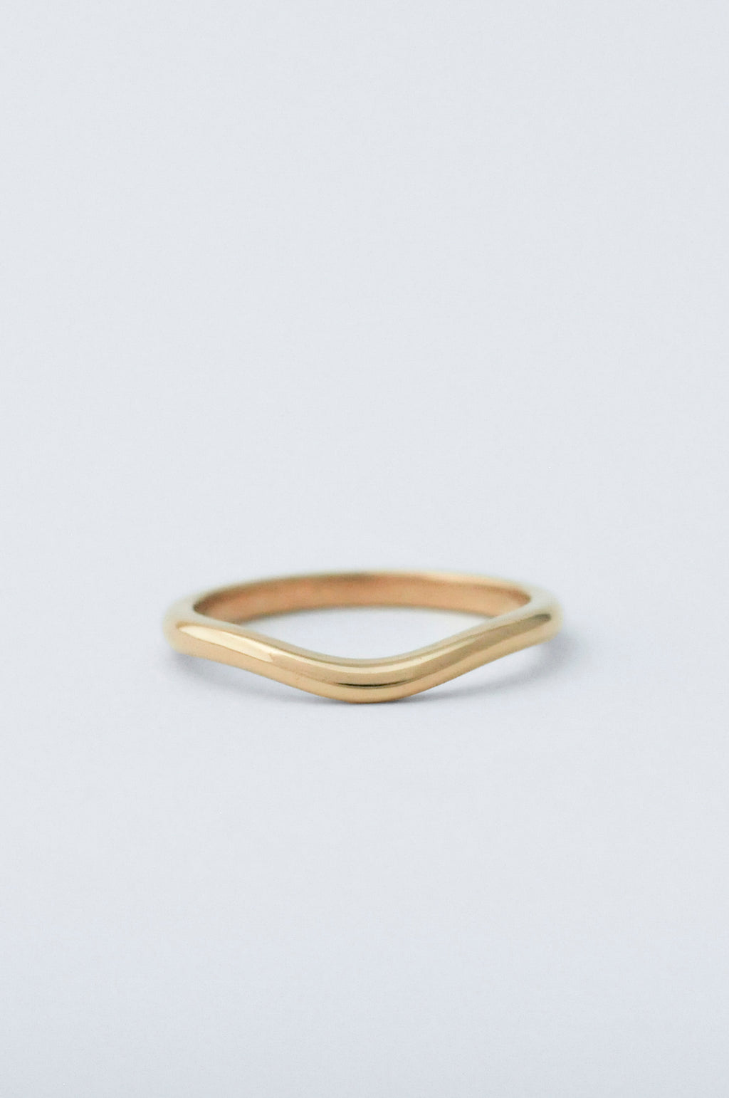 A gold ring with a curve detailing 