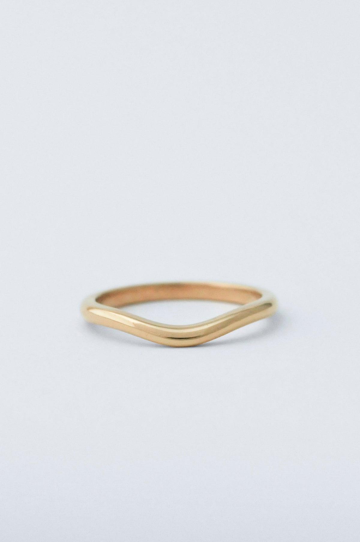A gold ring with a curve detailing 